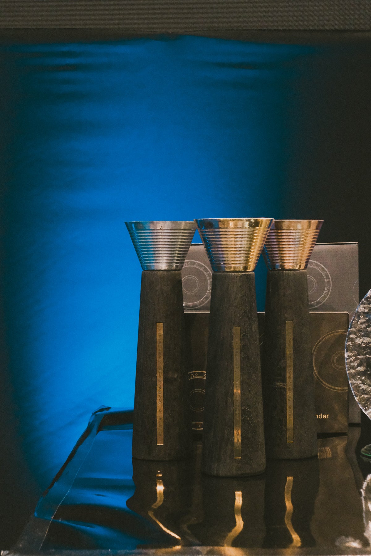 The SOLO Battle trophies, three of them standing against the blue hall backdrop